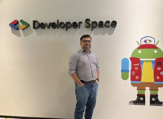 Tanveer Riaz beside a Developer Space sign and a painted Android mascot