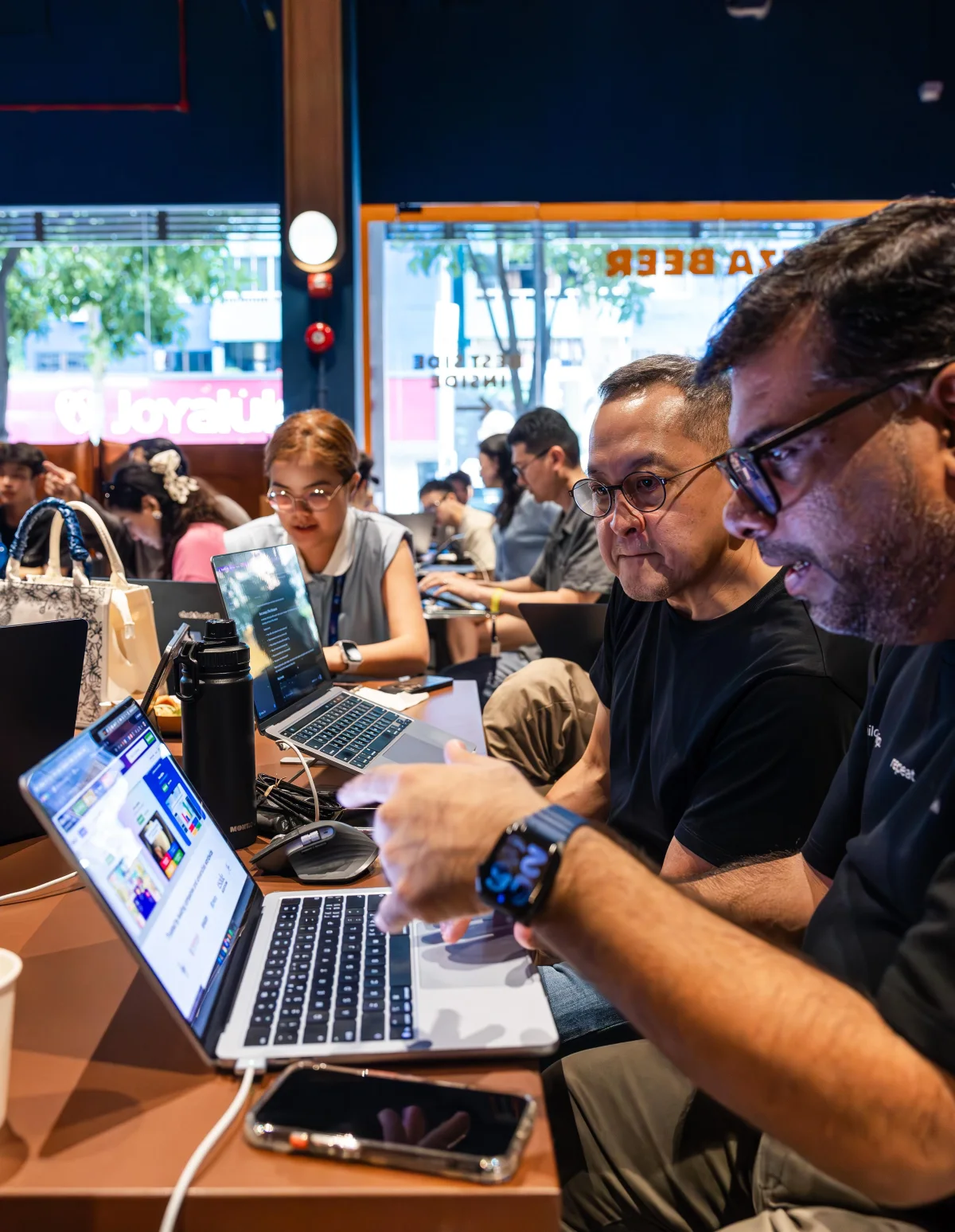 Benny and Tanveer Riaz working beside each other on laptops during the hackathon